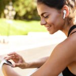 close-up-happy-fitness-woman-leaning-rail-Beats-Wireless-Earbuds